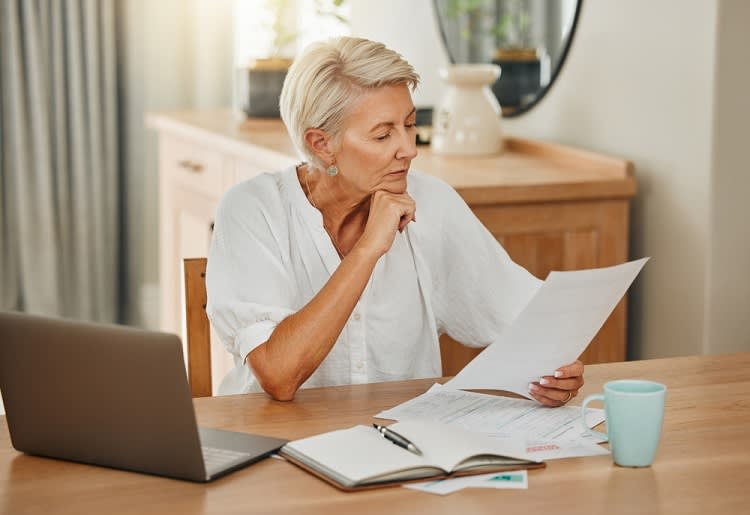 Older woman looking at documents at table