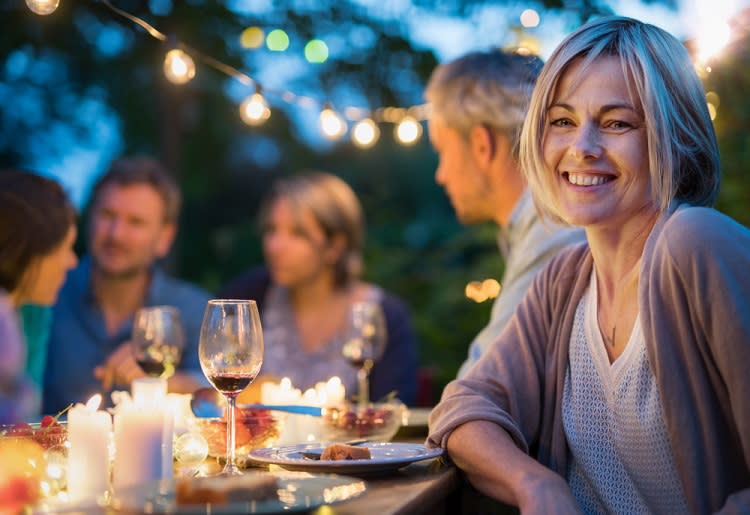 Smiling woman having dinner with group of friends