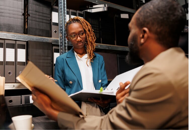 Man and woman in a warehouse looking at paperwork