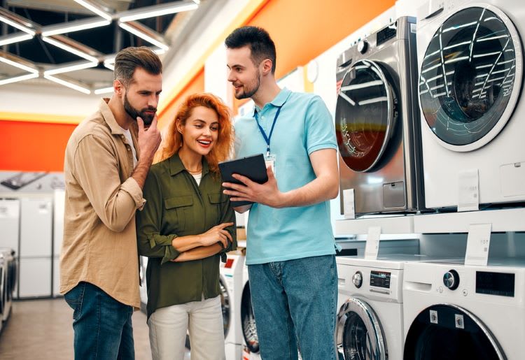 Couple in an appliance store, looking at new dryer options. 