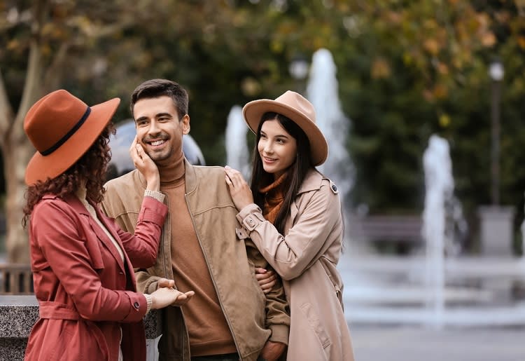Man smiling at his two female partners