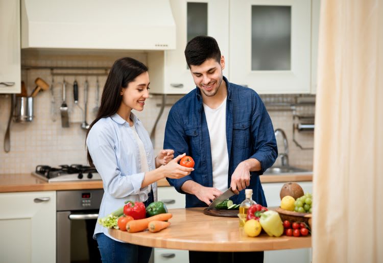 Couple preparing vegetables in the kitchen.