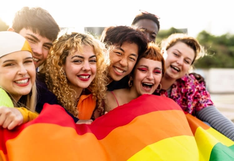 Diverse friends holding a pride flag