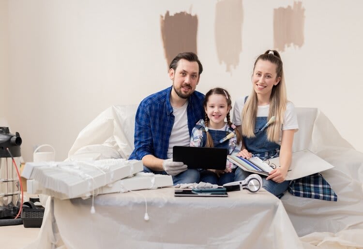 A family seated in their living room prior to a DIY painting project.