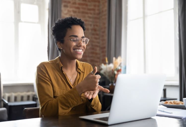 Online therapist signing "Help" to a hard-of-hearing patient.