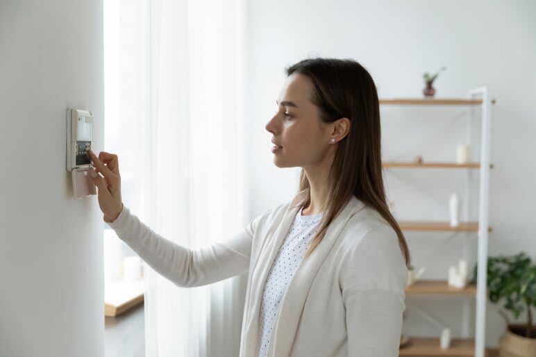 a woman is selecting options on her home security system