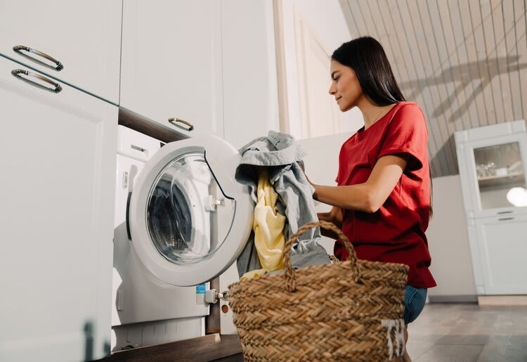 A young woman busy doing her laundry.