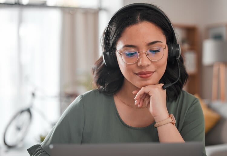 A woman wearing headphones trying to decide between VoIP and UCaaS.