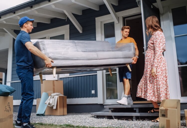 A man from a charity collecting a couch that a family donated