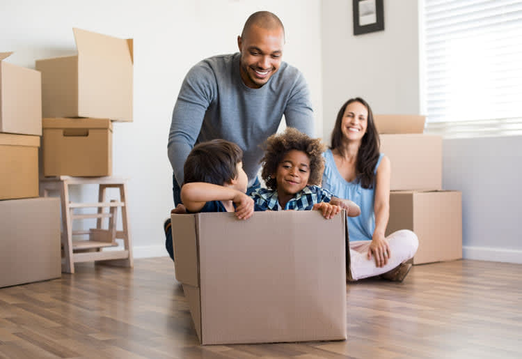 A family moving in to a new home using eco-friendly moving supplies.