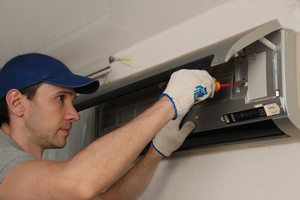 An electrician fixing an air conditioner.