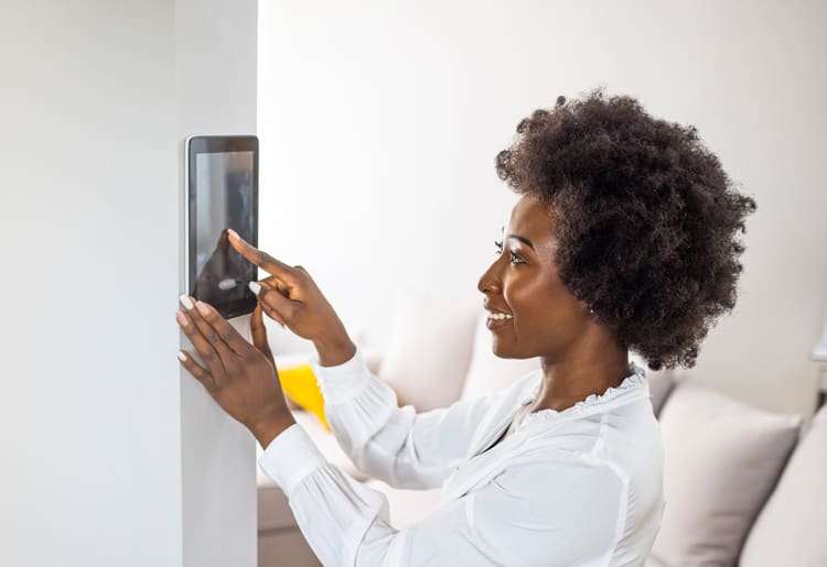 A woman using a smart security system to protect her home. 