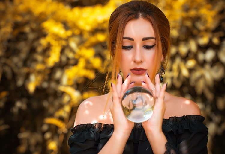 Woman holding and looking at crystal ball
