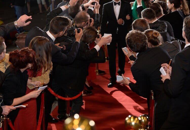 Paparazzi snapping images as a celebrity couple arrives on the red carpet.