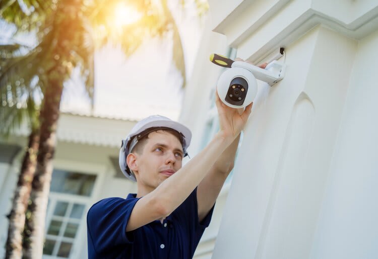 A man installing a home security camera.