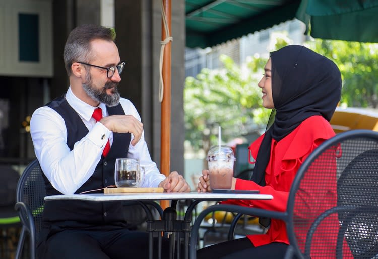 A man and Muslim woman on a date at a coffee shop