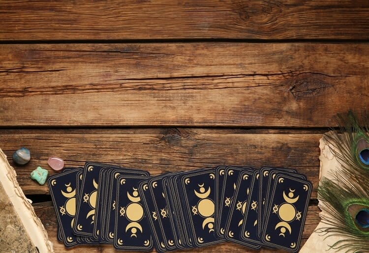 A deck of tarot cards spread out on a wooden table