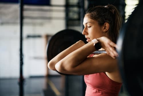 A woman working out at the gym with a barbell