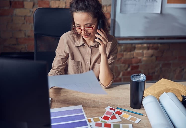 A woman talking on her phone while deciding colors to use for her site