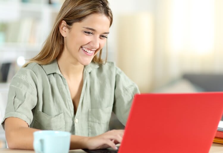 Smiling person using a laptop.