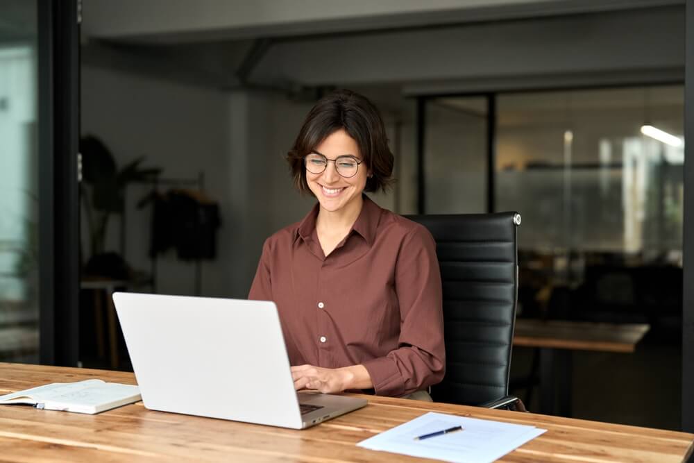 a desk with two computer monitors and a laptop