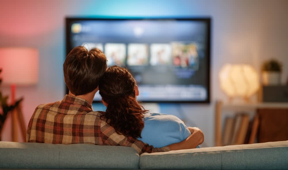 Happy family watching TV, movies in the evening at home. Couple spending time together. Happy family watching TV, movies in the evening at home. Couple spending time together.