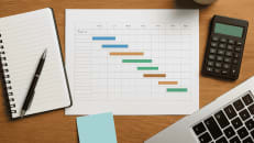 a desk with a calculator, notebook, pen and a calculator