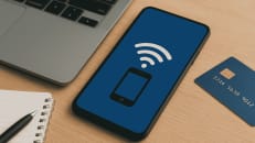 a cell phone sitting on top of a table next to a laptop