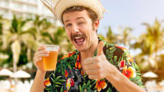 A young man drinking a beer is growing a mustache in support of Movember