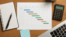 a desk with a calculator, notebook, pen and a calculator