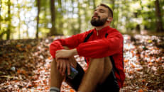 A young man sits in the forest to relax during Sober October