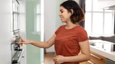 Housewife Using Modern Stove While Preparing Food At Home.