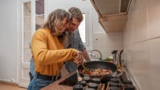 Young couple cooking together on a kitchen.
