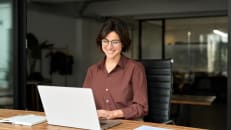 a desk with two computer monitors and a laptop