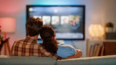 Happy family watching TV, movies in the evening at home. Couple spending time together.