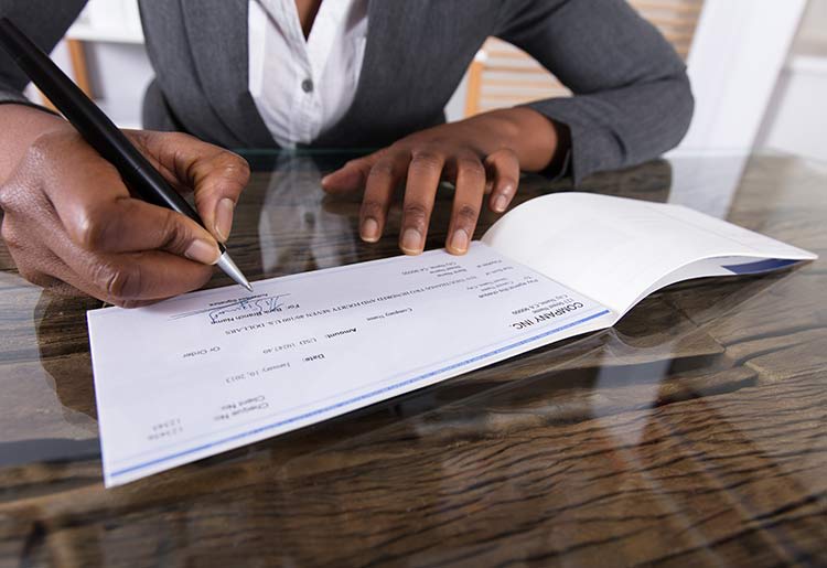 Woman signing business check
