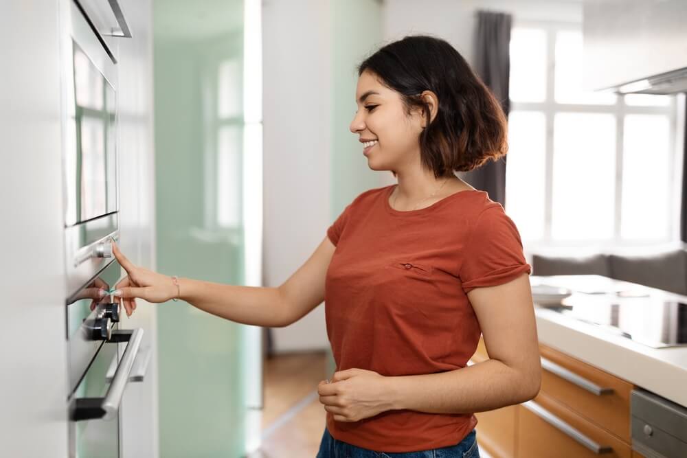 Housewife Using Modern Stove While Preparing Food At Home.